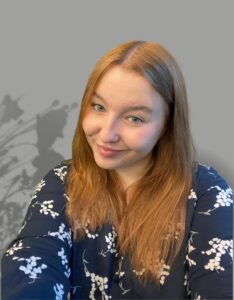 Kuva hymyilevästä ruskeahiuksisesta naisesta